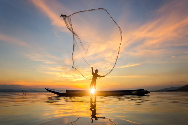 A fishing man on Tonlé Sap River at sunset