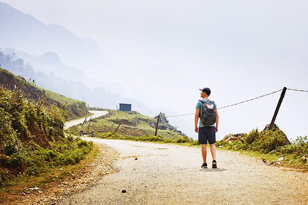 A hiker admiring the scenery on a winding road