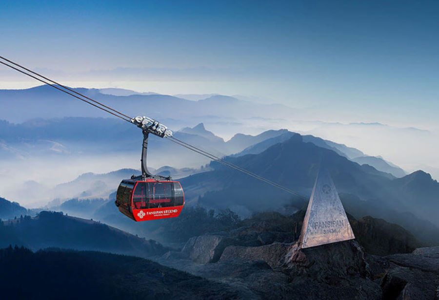 Fansipan cable car soars above clouds, revealing breathtaking mountain views below.
