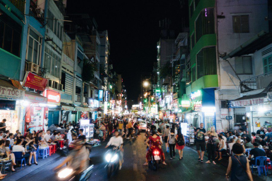 Vibrant street in Ho Chi Minh City at night with coffee shops ahd nightbars - Vietnam Explorer tour