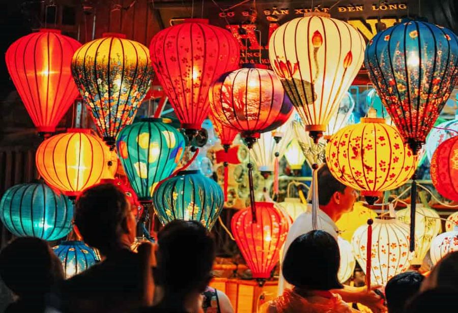Vibrant, handcrafted lanterns in Hoi An light up the night as crowds admire their glowing beauty during a bustling evening market.