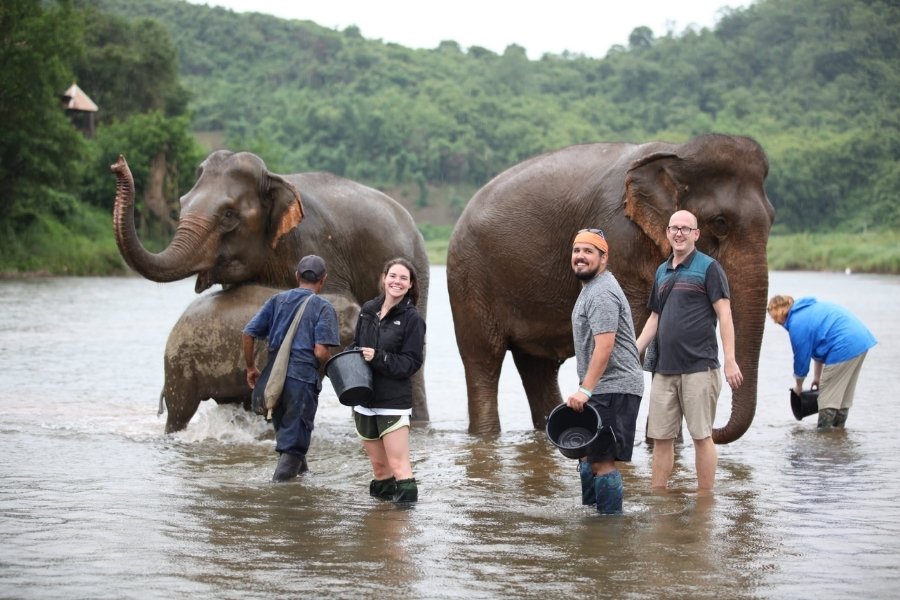 Travelers participate in elephant-bathing at a preservation camp in Laos