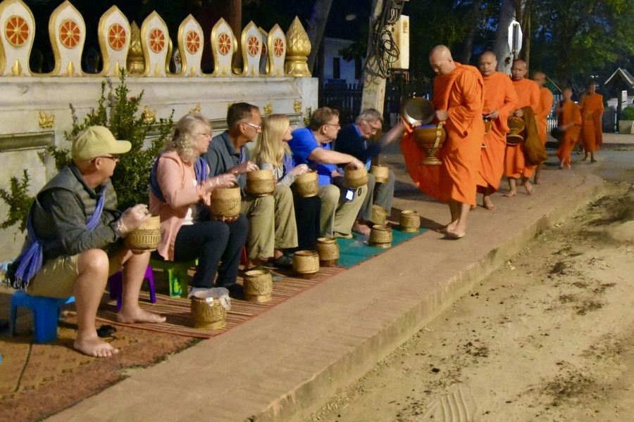 Monks receiving alms in the early morning streets of Luang Prabang, a meaningful experience for Laos tours in 2026