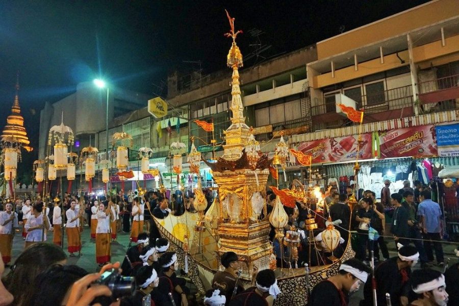 Loy Krathong festival in Thailand featuring a grand, ornate parade with a golden float adorned with intricate decorations, carried by participants in traditional attire