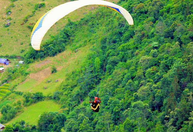 Tandem paragliding over Khau Pha Pass during the golden season