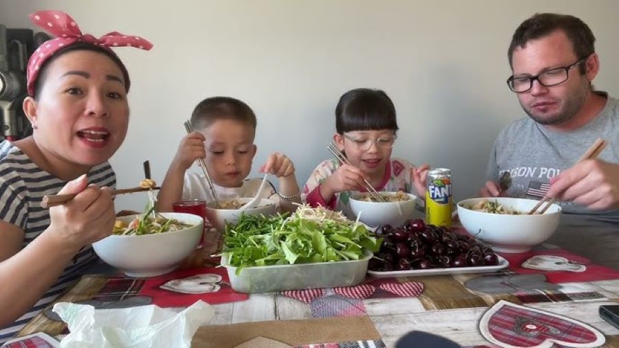 Family gathers around warm Pho noodle soup, sharing smiles and cherished moments together