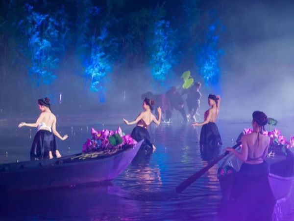 The young girls picking up lotus flower by the pond