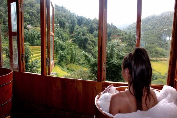 Woman taking a herbal bath in Sapa with view of the rice paddies