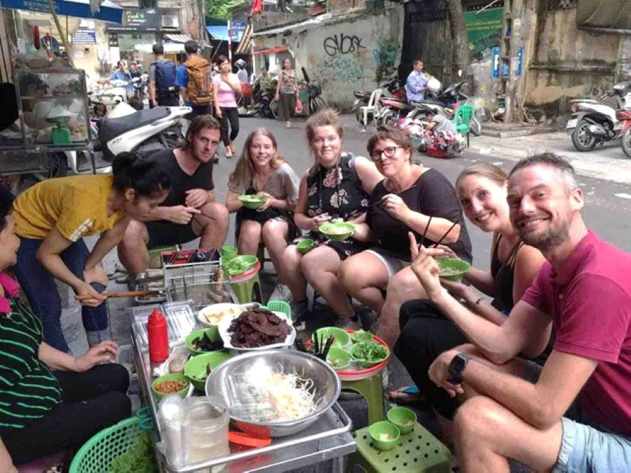 Pho noodle soup brings foreign travelers together over authentic Hanoi street flavors.