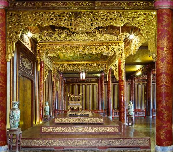 The emperor's throne is located at the center of the palace, flanked by decorative screens and royal insignias.
