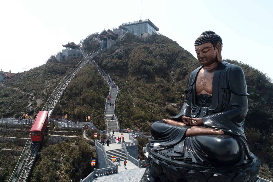 Fansipan cable car journey ends near the majestic Great Buddha watching over mountains.