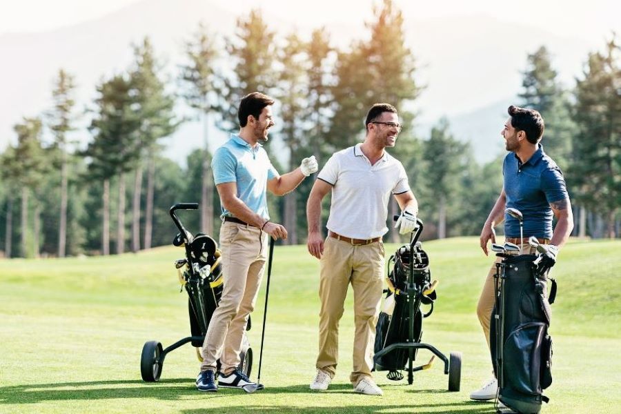 Three golfers talking in a golf course in Central Vietnam.